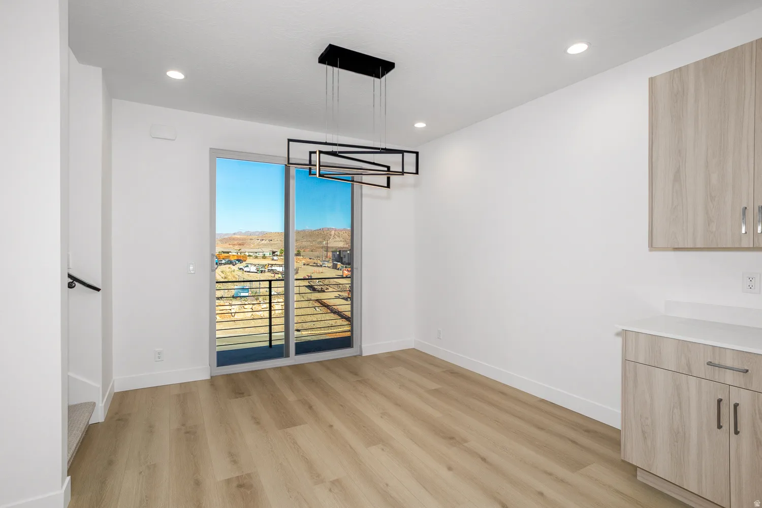 Unfurnished dining area featuring light wood-type flooring, recessed lighting, and a mountain view