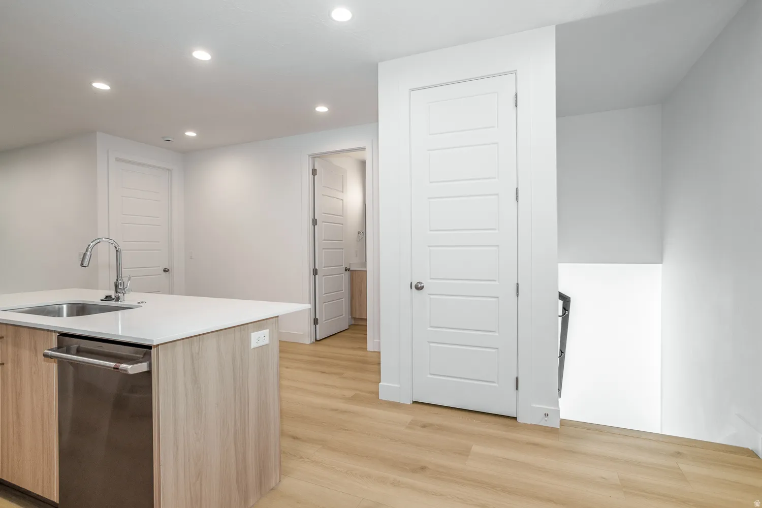 Kitchen with dishwasher, recessed lighting, light wood-style floors, modern cabinets, and a center island with sink