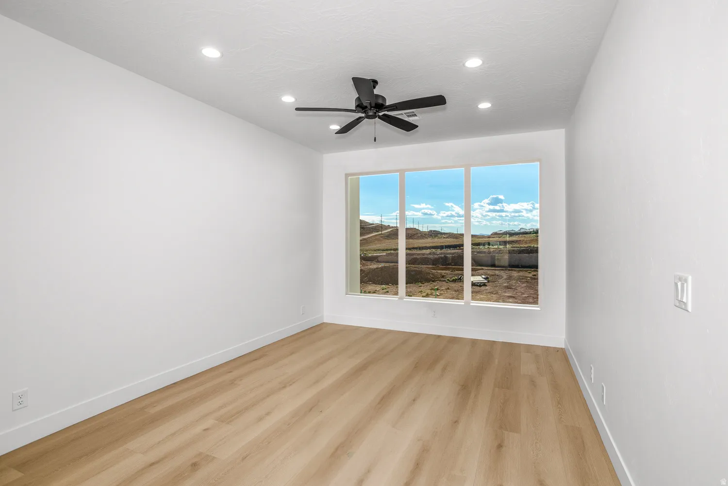 Unfurnished room featuring light wood-type flooring, a ceiling fan, and recessed lighting