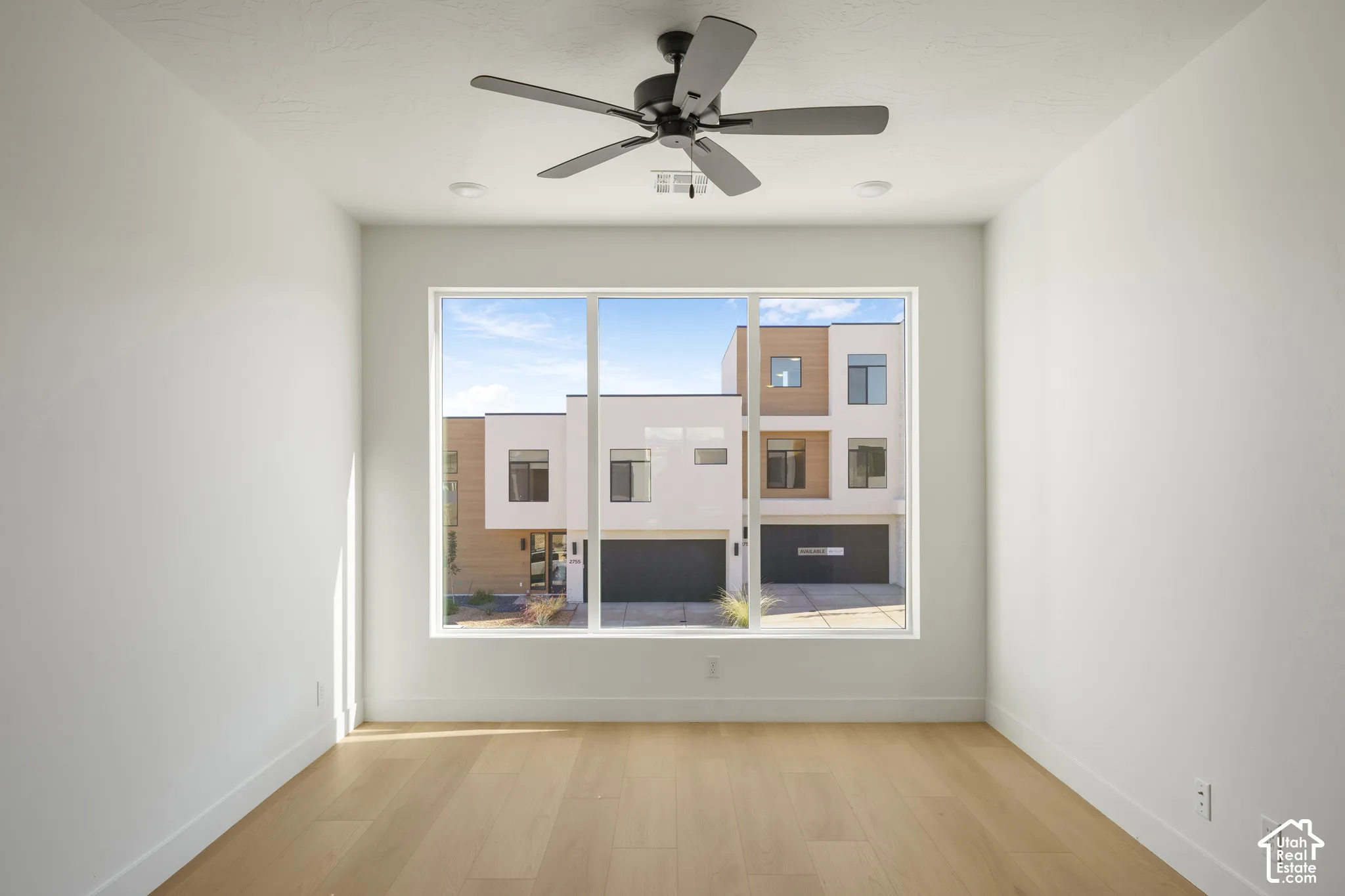 Large picture window, wood-finish flooring, recessed lighting, and a multi-blade ceiling fan