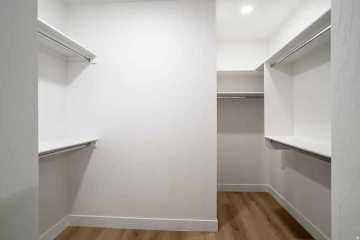 Walk in closet with light wood-type flooring
