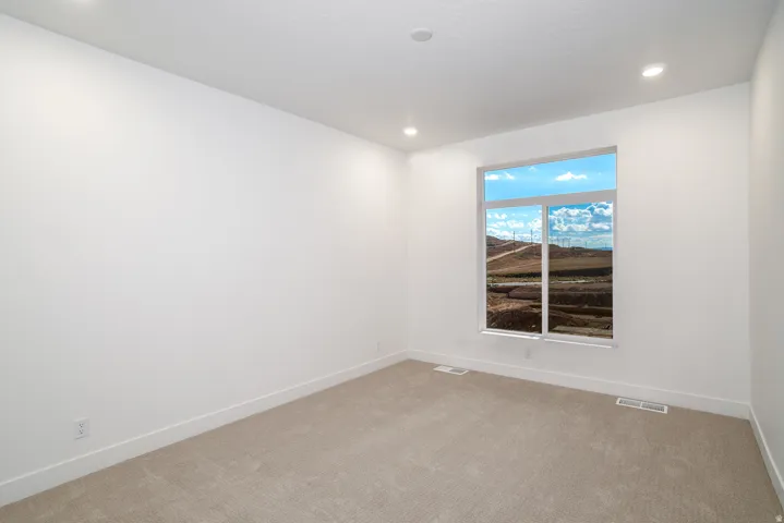 Empty room featuring light colored carpet and recessed lighting