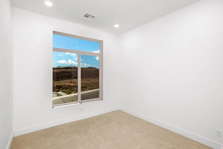 Carpeted empty room with baseboards and recessed lighting