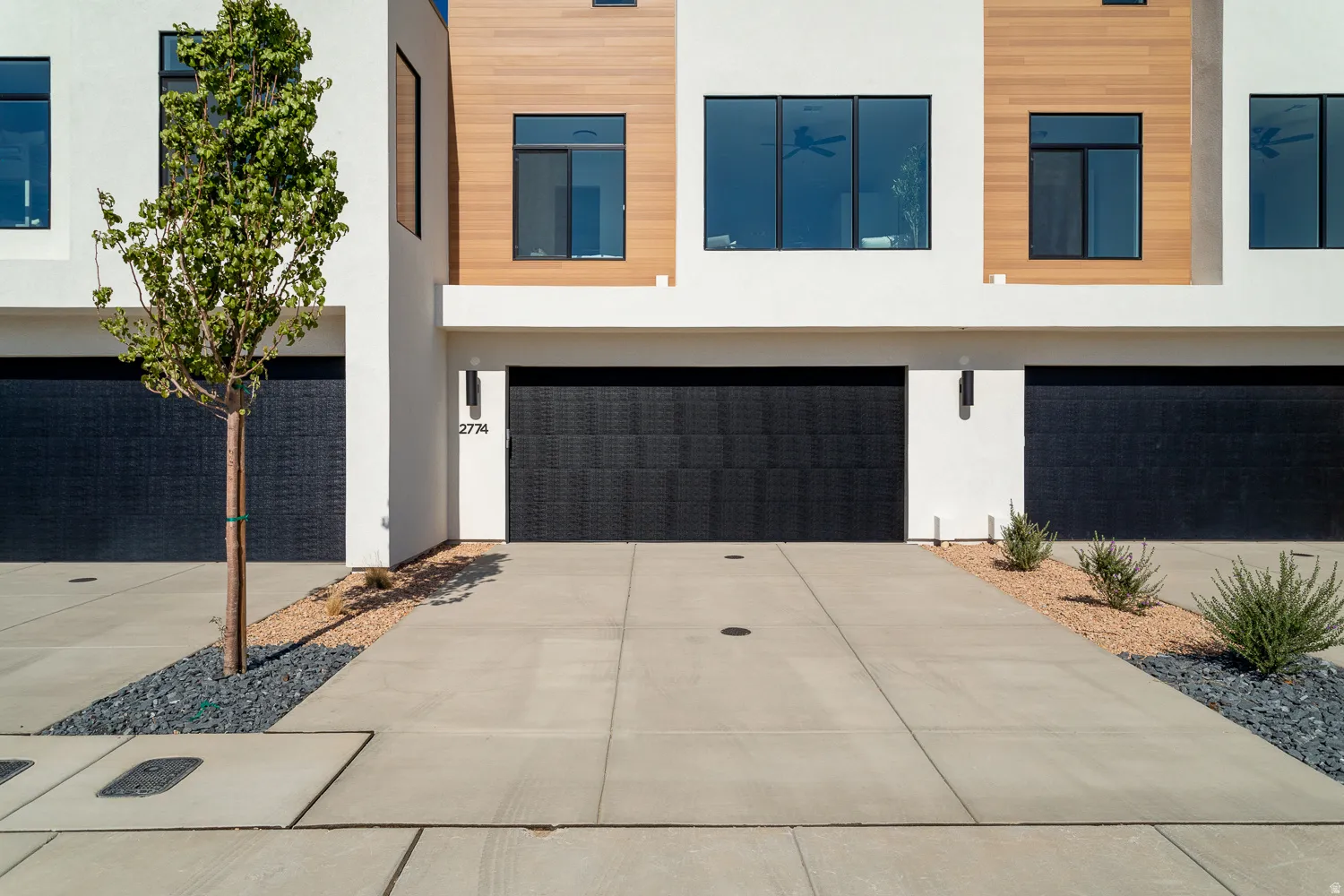 Modern home with a garage, stucco siding, and driveway