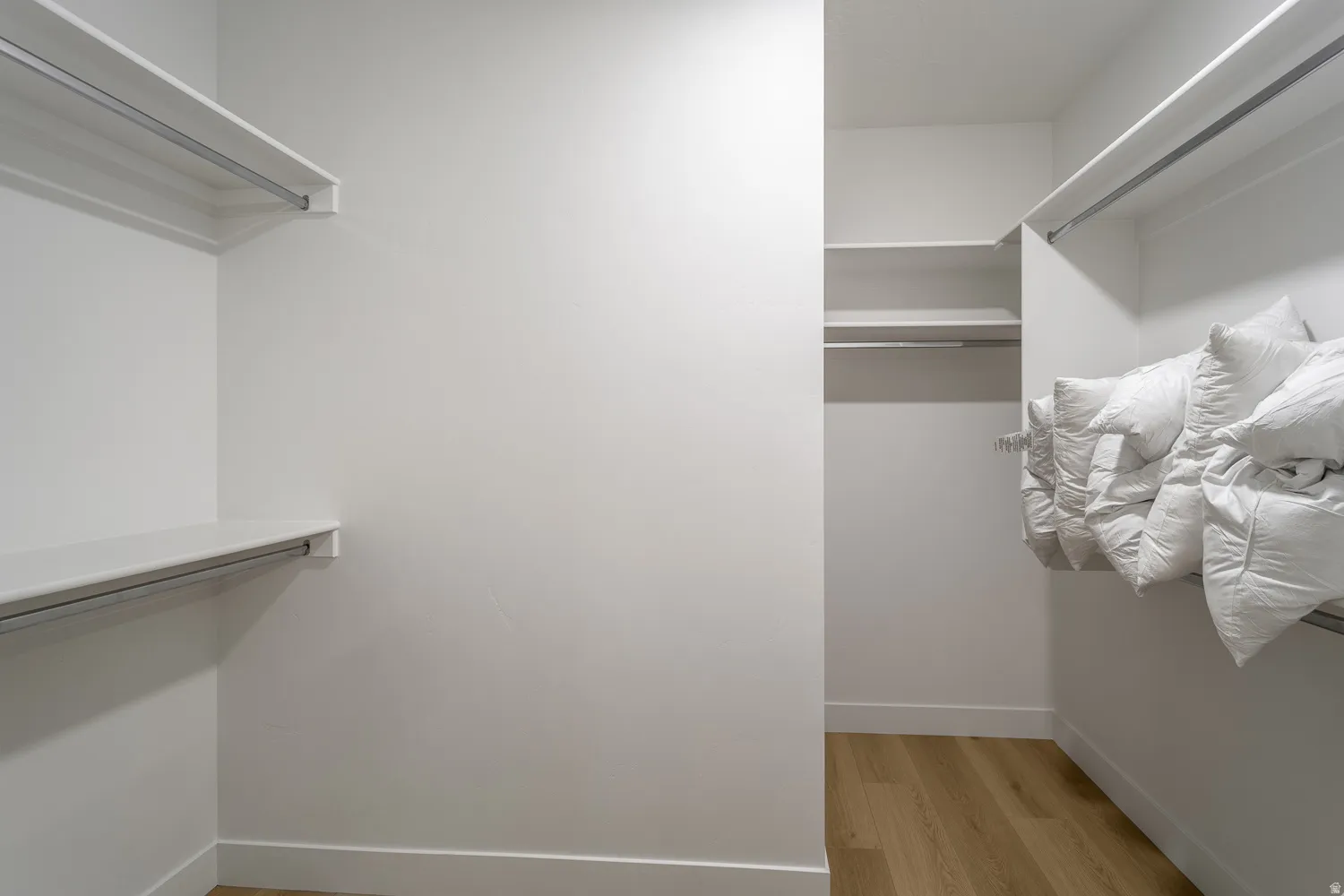Walk in closet with light wood-style floors