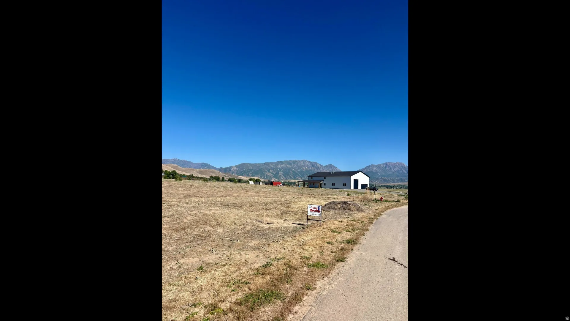 Expansive undeveloped lot featuring a paved road frontage and mountain scenery