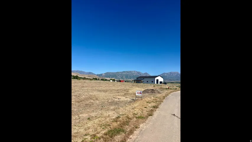 Expansive undeveloped lot featuring a paved road frontage and mountain scenery