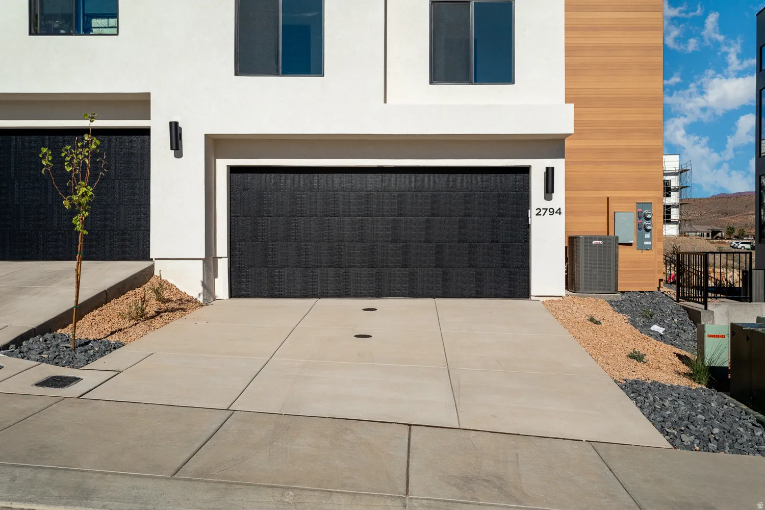 Contemporary home featuring an attached garage, concrete driveway, and stucco siding