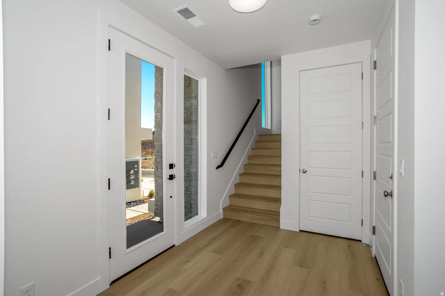Doorway with stairs and wood finished floors