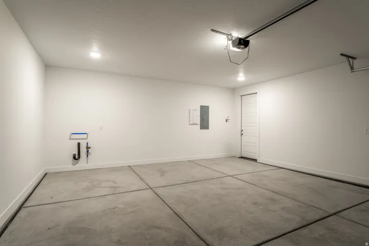 Garage featuring baseboards and electric panel