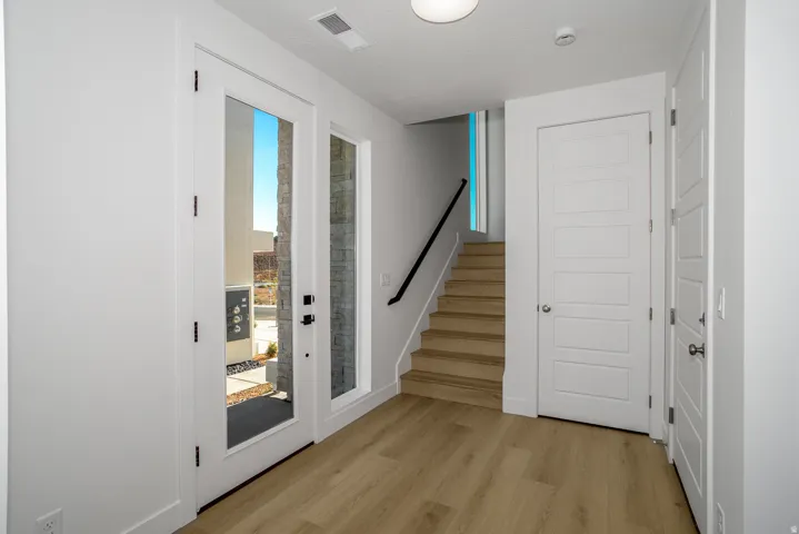 Doorway with stairs and wood finished floors