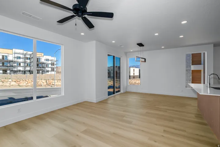 Empty room with light wood-type flooring, ceiling fan, healthy amount of natural light, and recessed lighting