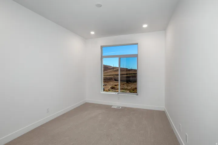 Carpeted empty room featuring baseboards and recessed lighting