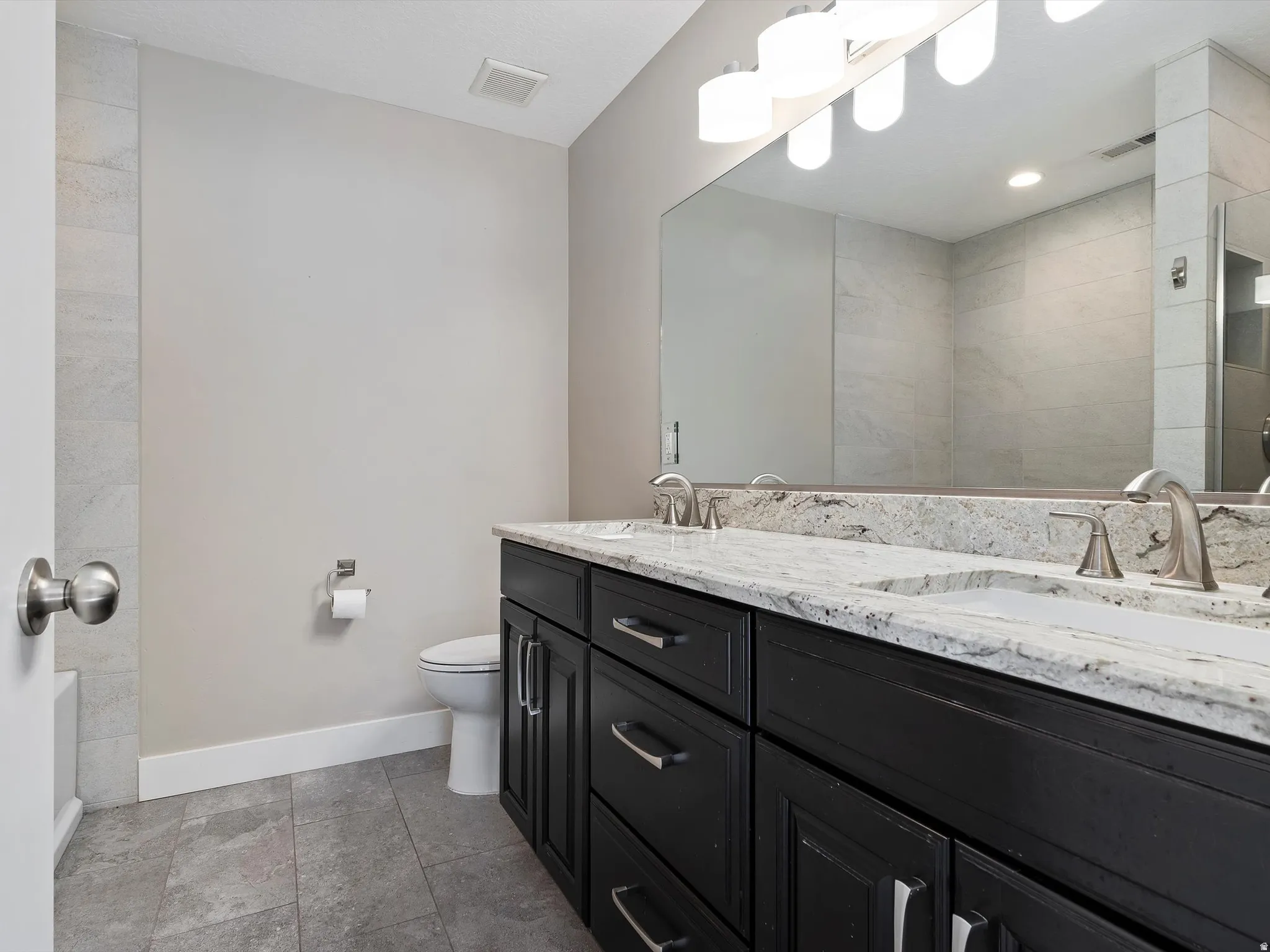 Full bathroom with double vanity and a tile shower