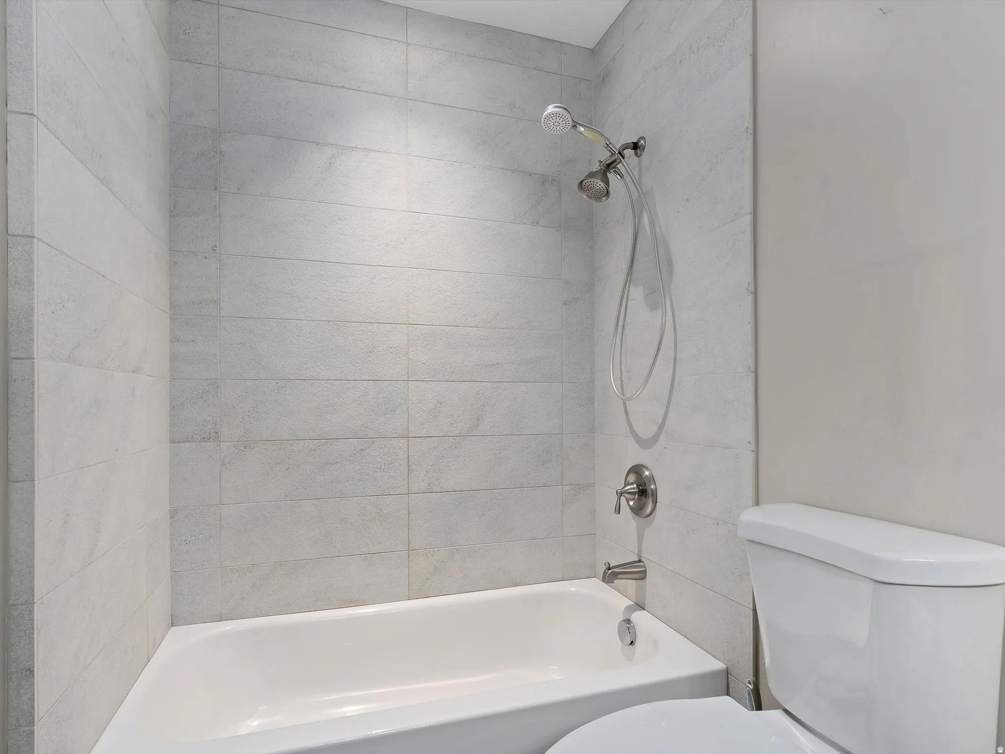 Full bath featuring toilet and tub / shower combination