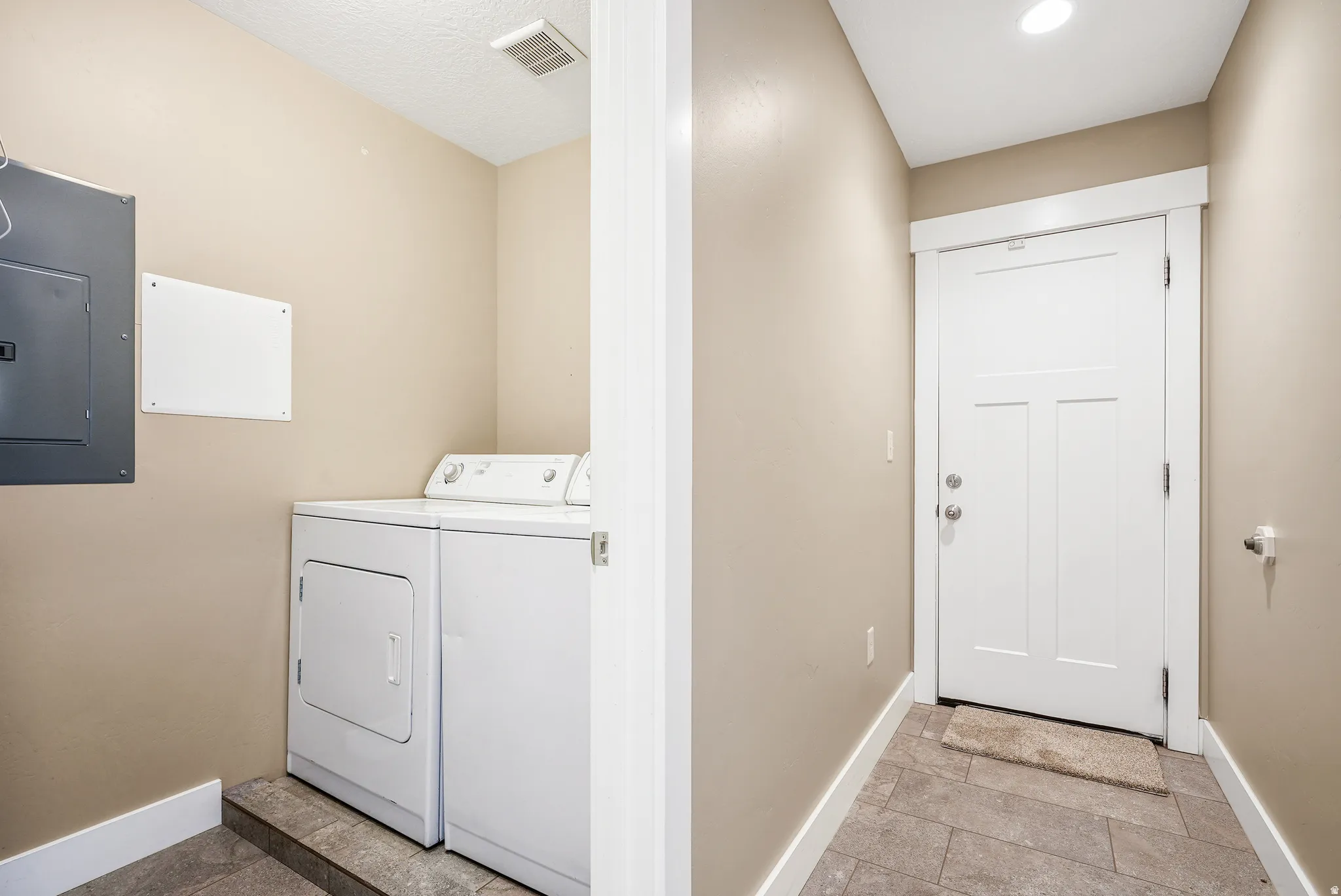 Laundry area featuring electric panel and separate washer and dryer