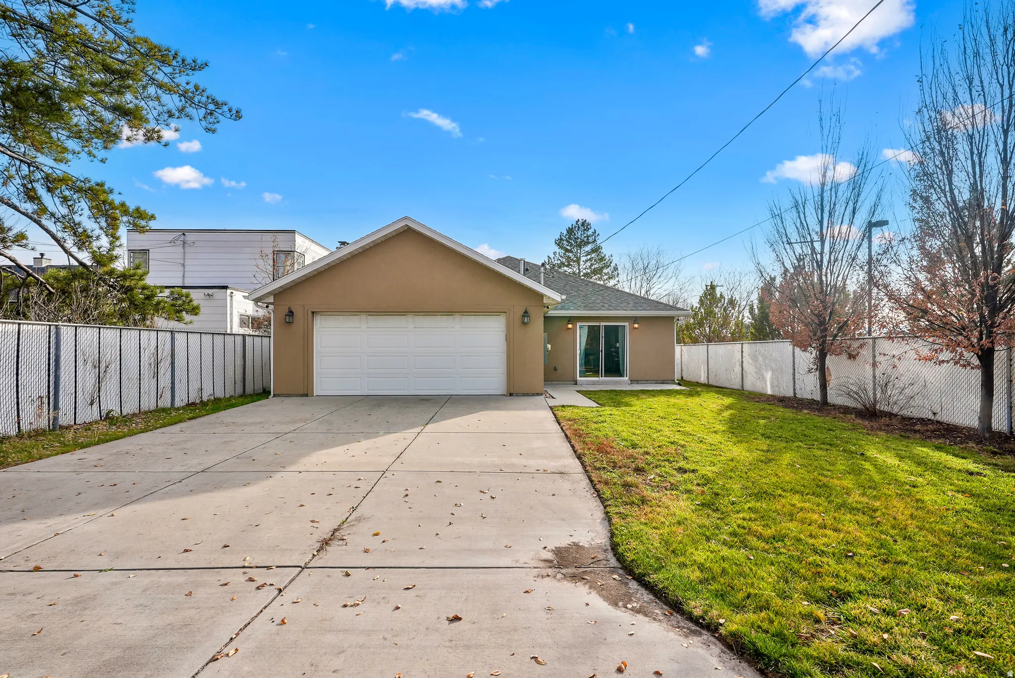 View of front of home featuring stucco siding, concrete driveway, and an attached garage