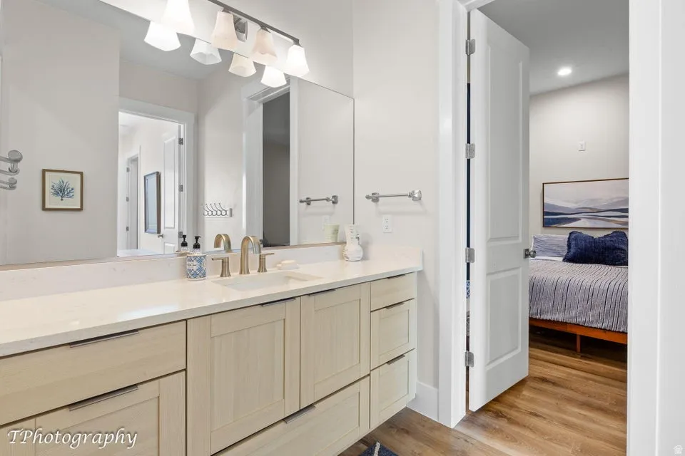 Ensuite bathroom with vanity, light wood-type flooring, and recessed lighting