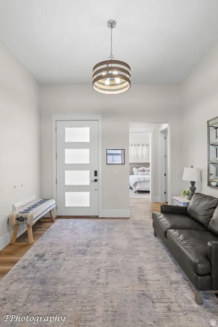 Entryway with wood finished floors and hanging lights
