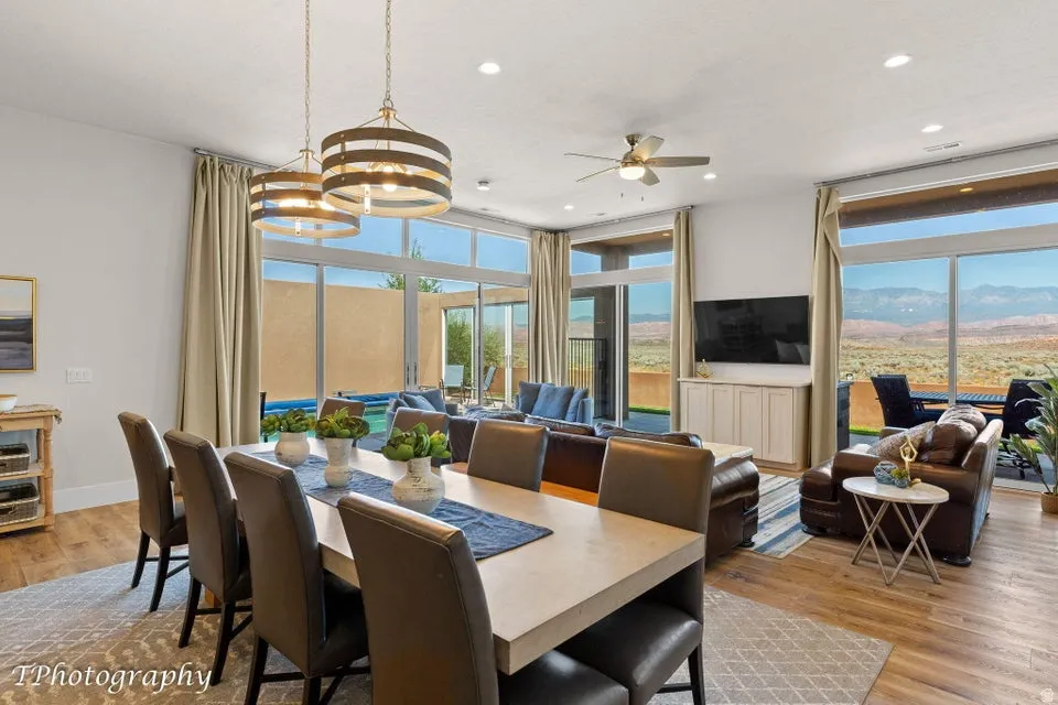 Dining area with light wood-style flooring, a ceiling fan, and hanging lights