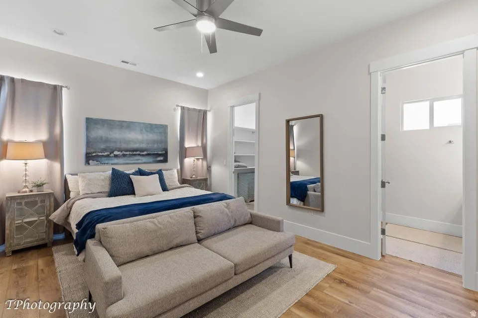 Bedroom with a spacious closet, light wood-type flooring, a ceiling fan, and recessed lighting