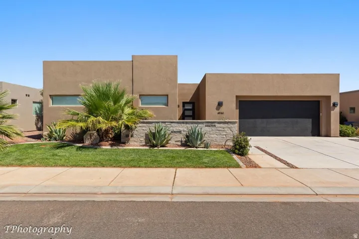 Southwest-style home with stucco siding, driveway, and an attached garage