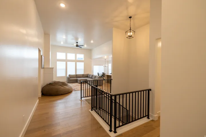 Hall featuring an upstairs landing, hardwood / wood-style floors, and recessed lighting