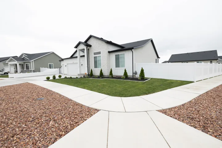 View of front of home with board and batten siding, driveway, and a garage