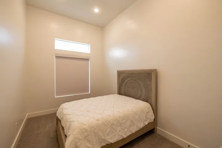 Bedroom with dark carpet and recessed lighting