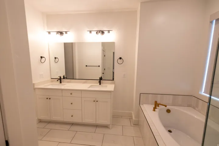 Bathroom featuring double vanity and a bath