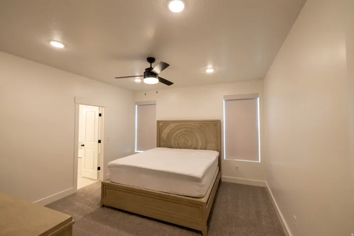 Carpeted bedroom featuring a ceiling fan and recessed lighting