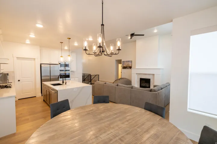 Dining space with suspended lighting, a tiled fireplace, and light wood-style flooring