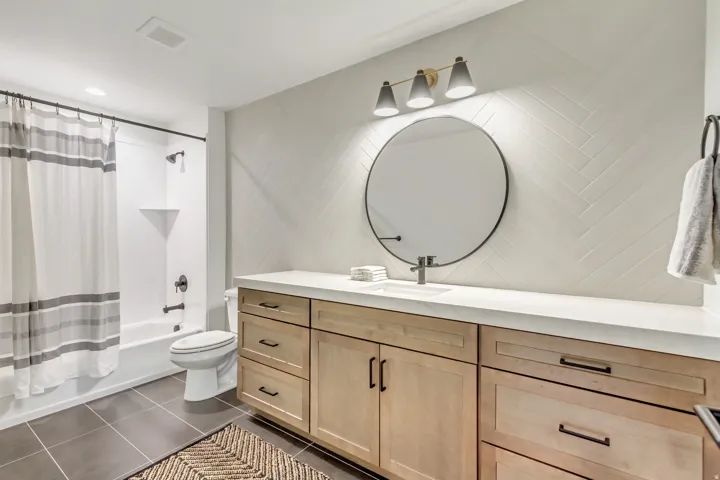 Bathroom featuring vanity, dark tile patterned flooring, and shower / bath combo