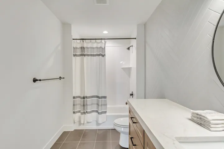 Full bathroom with vanity, shower / tub combo with curtain, dark tile patterned floors, and recessed lighting