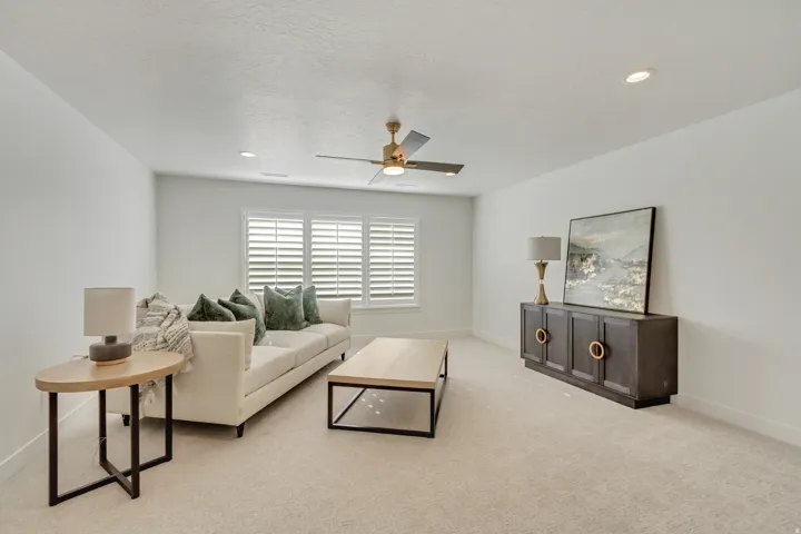 Living area with light carpet, ceiling fan, and a textured ceiling