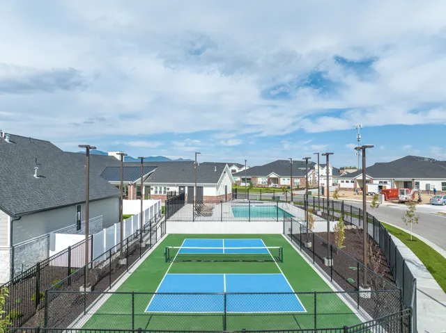 View of tennis court with a residential view
