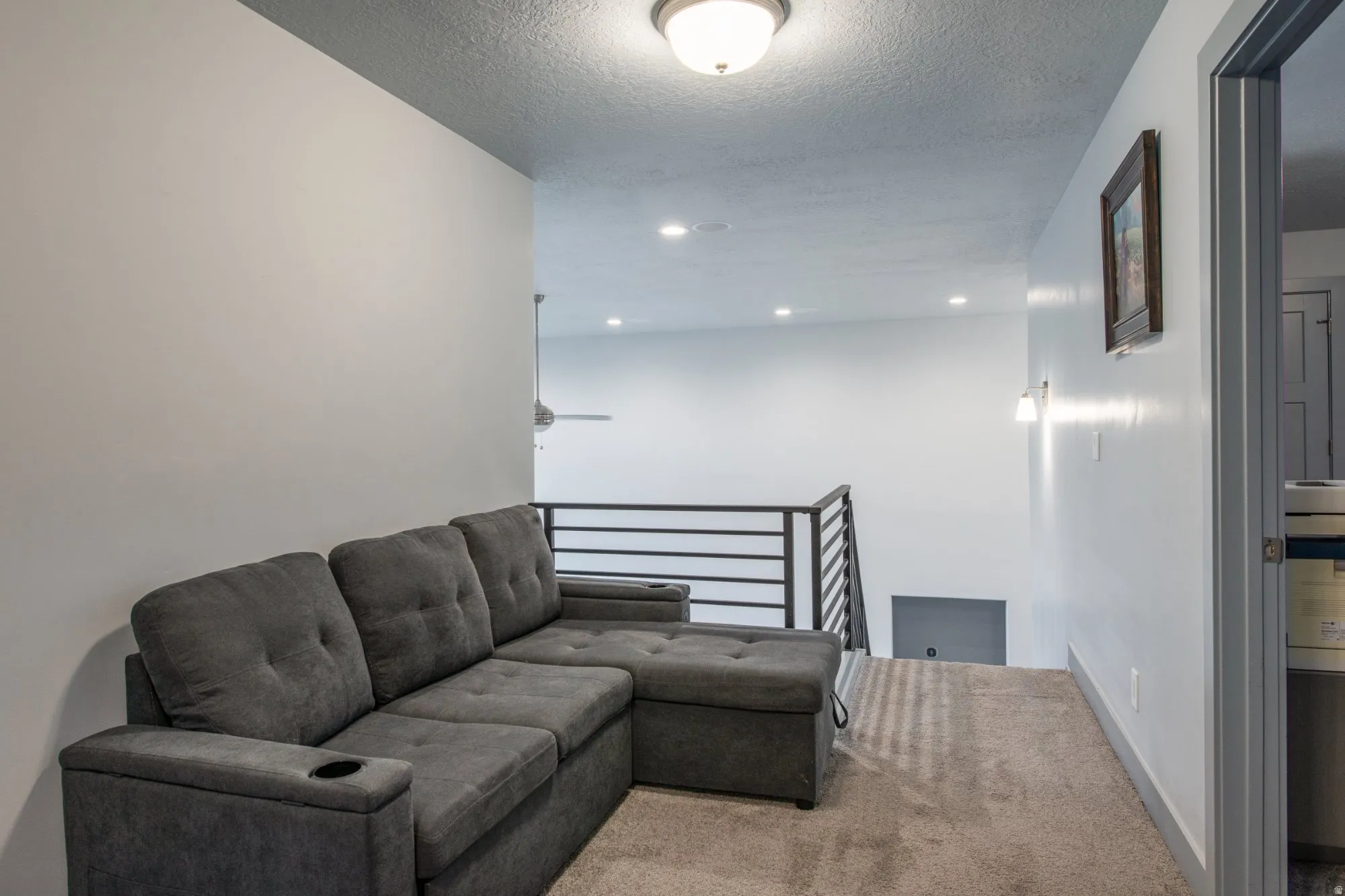 Sitting room featuring an upstairs landing, carpet, a textured ceiling, and recessed lighting
