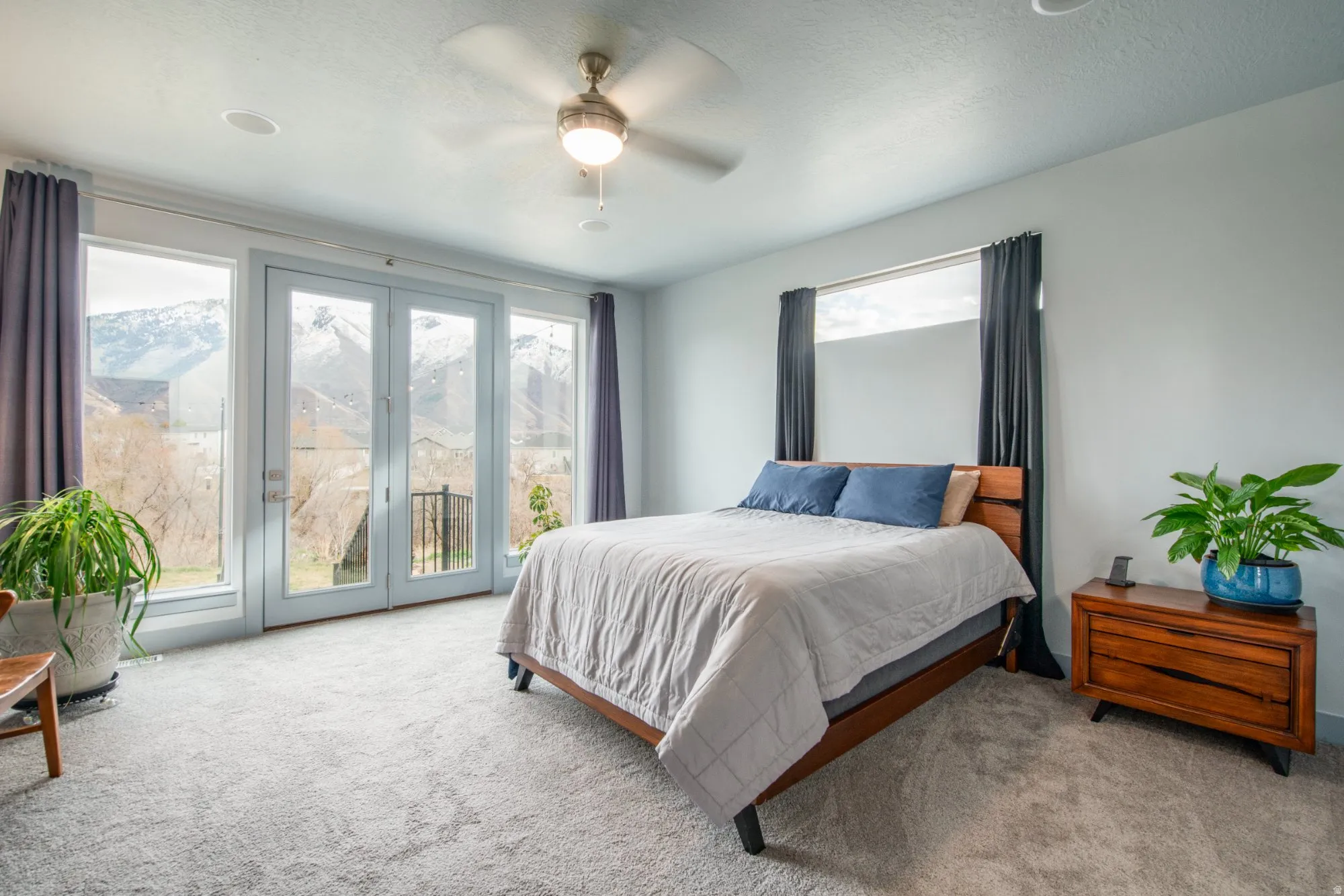 Carpeted bedroom featuring access to exterior, ceiling fan, and a textured ceiling