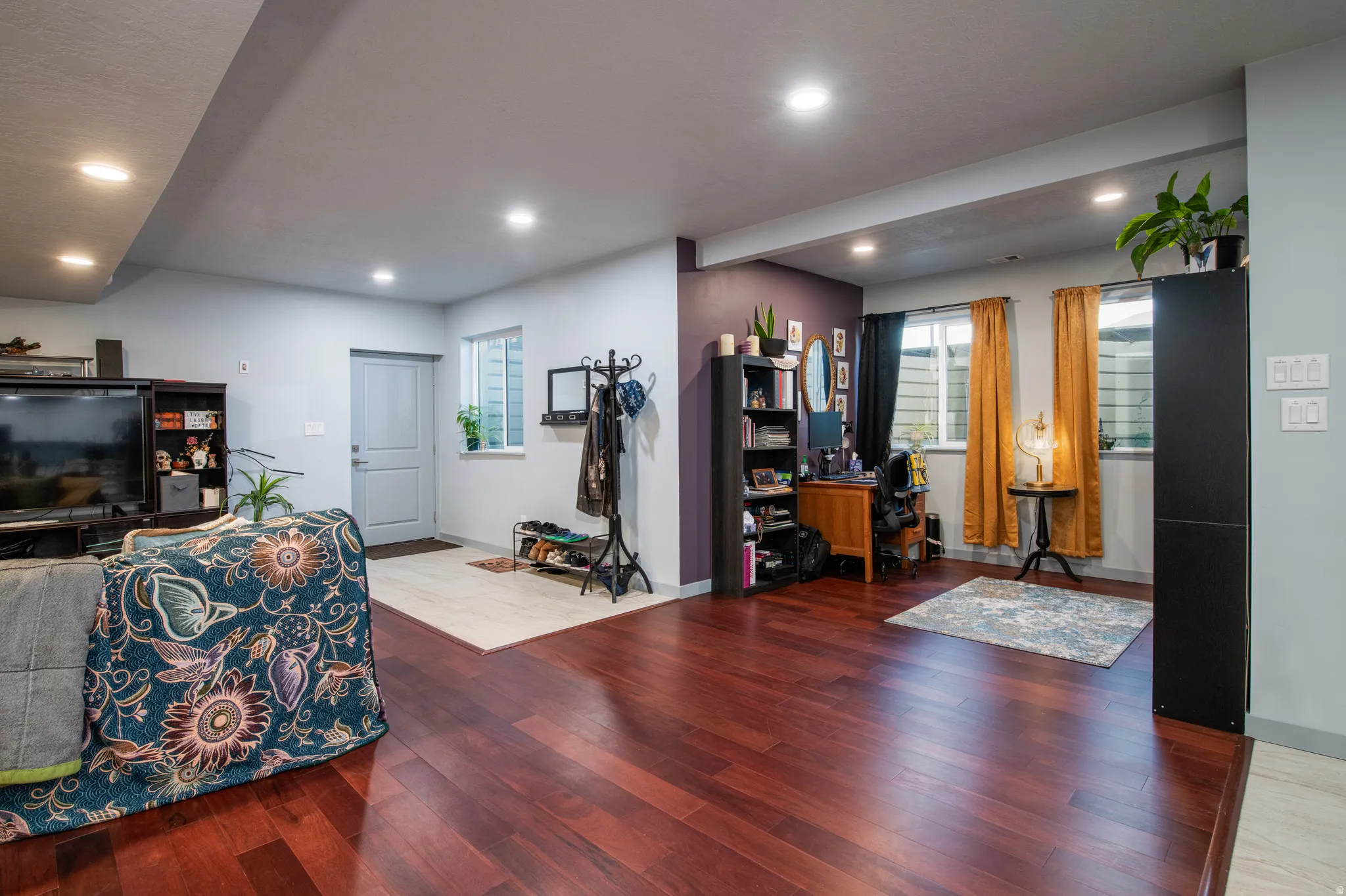 Rich wood-finish flooring throughout, recessed ceiling lighting, and a neutral wall palette