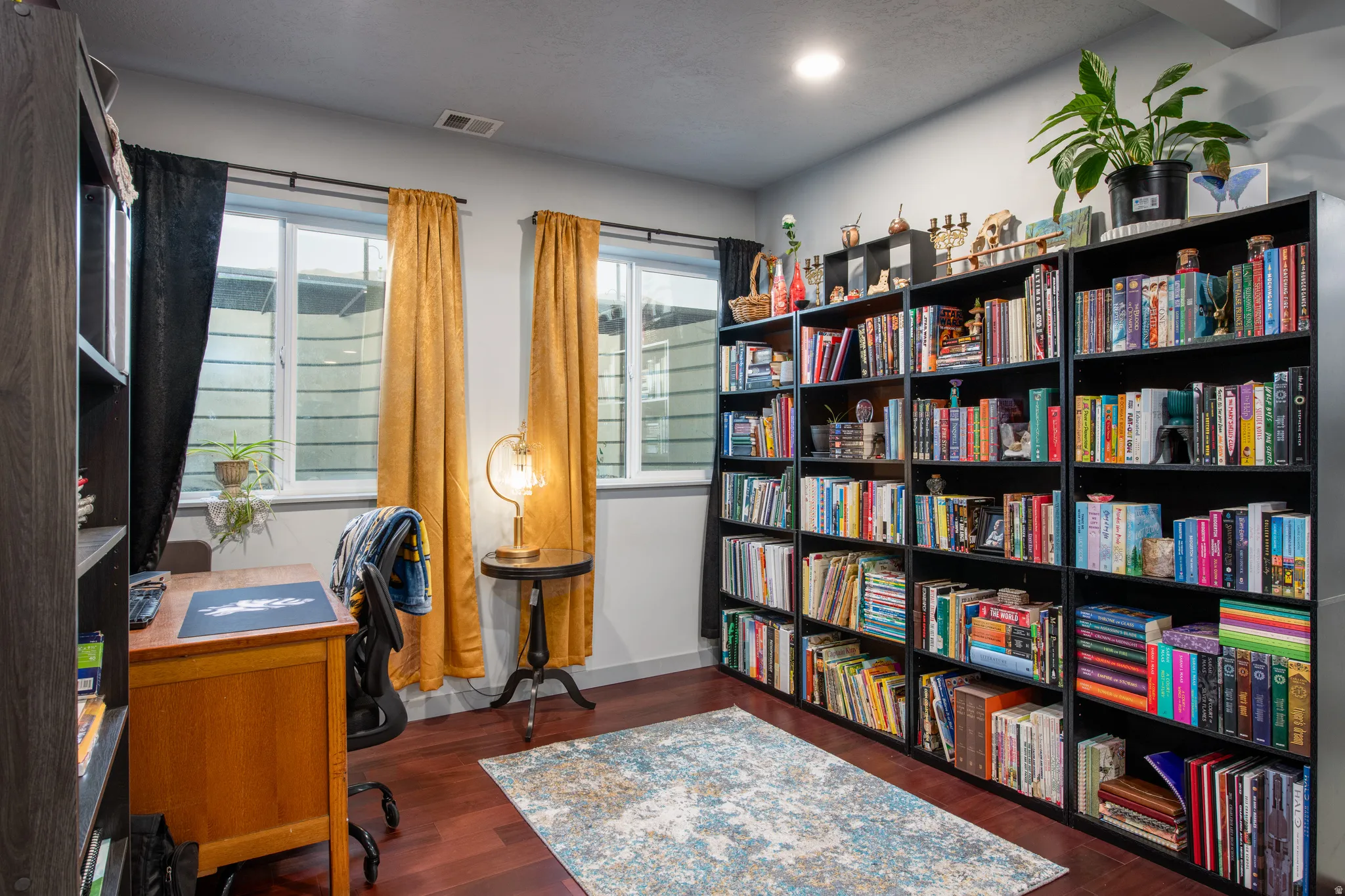 Expansive wall-to-wall built-in shelving, rich wood-finish flooring, and recessed ceiling lighting