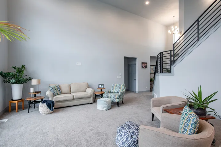 Vaulted ceilings, recessed lighting, and a modern staircase with black metal railings