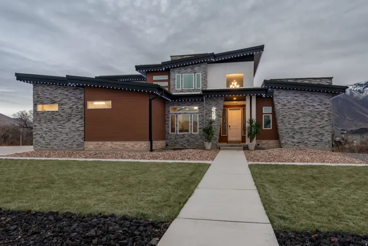 View of front of property featuring stone siding and a front lawn