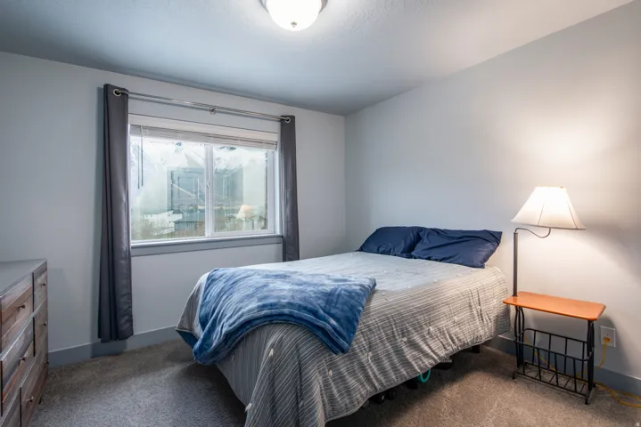 Carpeted flooring, white walls, and a window with gray trim