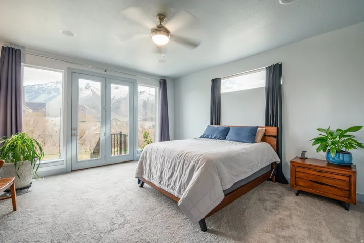 Carpeted bedroom featuring access to exterior, ceiling fan, and a textured ceiling