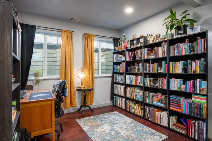 Expansive wall-to-wall built-in shelving, rich wood-finish flooring, and recessed ceiling lighting