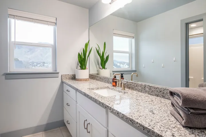 Single vanity with a light-toned countertop, undermount sink, and brushed nickel fixtures