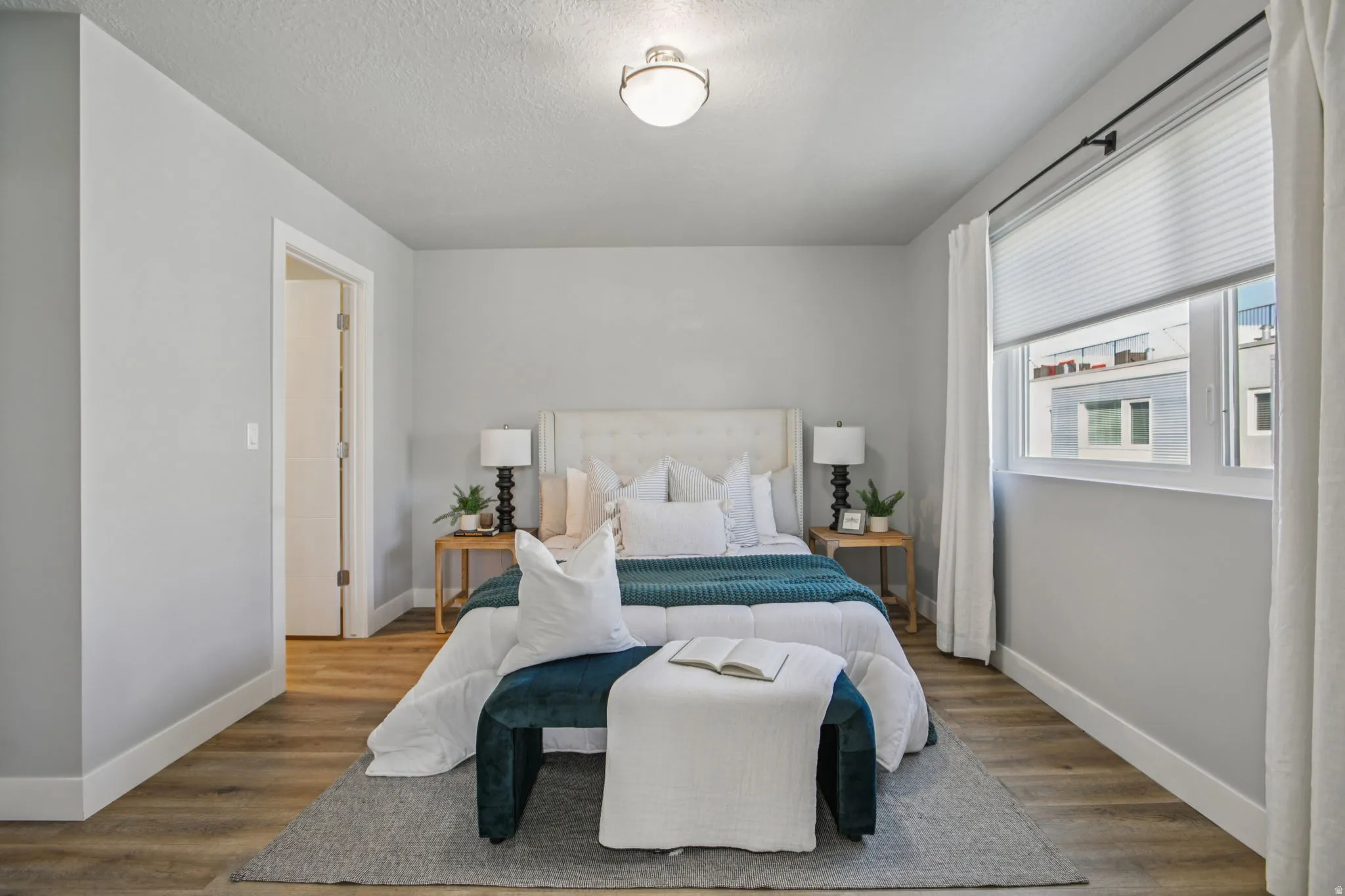 Bedroom with wood finished floors and a textured ceiling