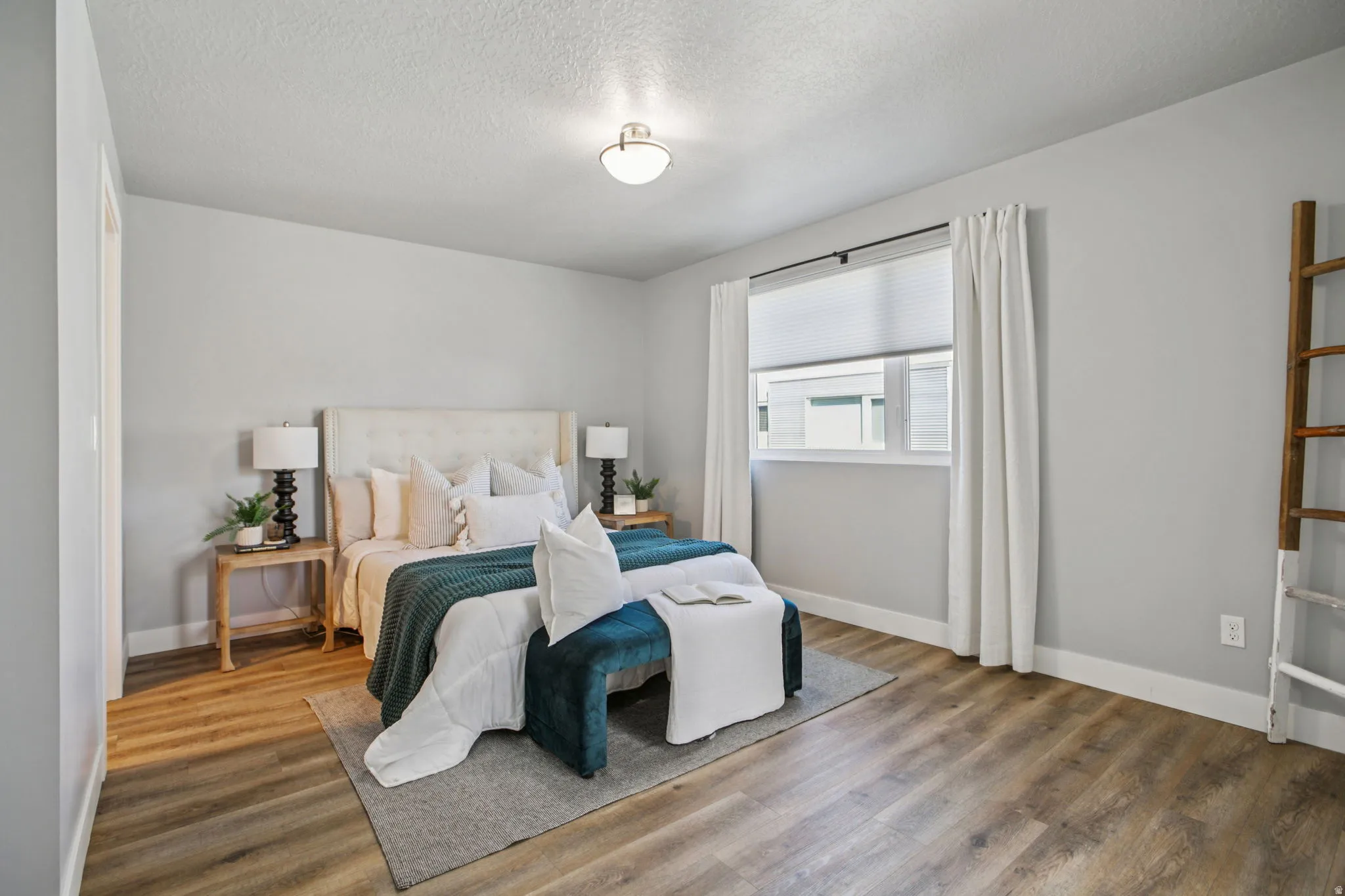 Bedroom with wood finished floors and a textured ceiling