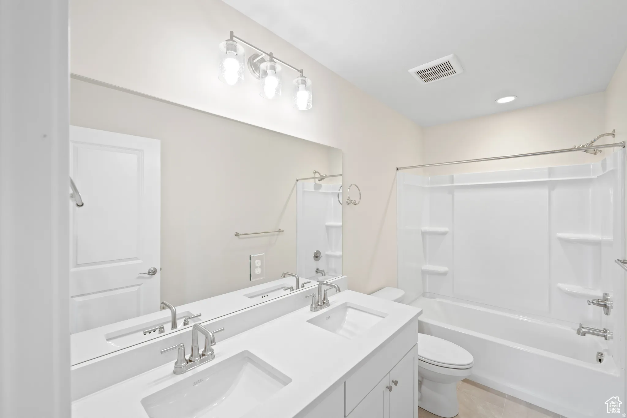 Full bathroom with double vanity and bathing tub / shower combination