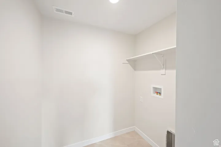 Laundry room with baseboards and washer hookup